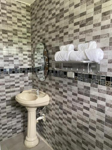 a bathroom with a sink and a mirror and towels at Missionary Guest House in Boca Chica