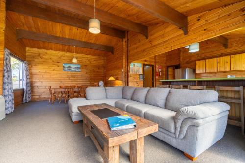 a living room with a couch and a table at Te Anau Top 10 Holiday Park and Motels in Te Anau