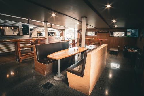 a restaurant with a wooden table and a bench at Te Mata Views Resort in Havelock North