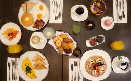 a table with plates of breakfast food on it at Hilton Garden Inn Bogota Airport in Bogotá
