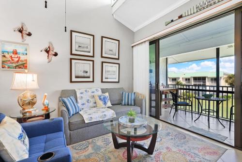 a living room with a couch and a table at Beachfront paradise Ocean Village Golf Tennis Several heated pools Tiki bar Pickleball insite sports bar and restaurant and much more in Fort Pierce