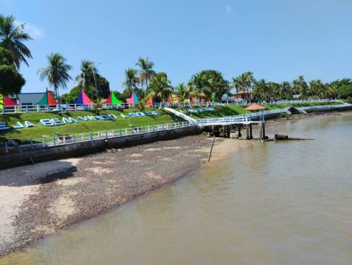 a view of a river with a beach and tents at Morada das mangueiras em Soure in Soure