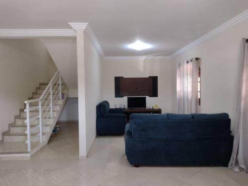 ein Wohnzimmer mit einem blauen Sofa und einem Fernseher in der Unterkunft casa de Vilatur in Saquarema