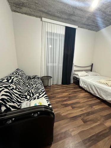 a bedroom with two beds and a wooden floor at Racha - ABA in Ambrolauri