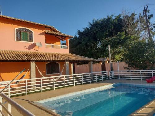 ein Haus mit Pool neben einem Zaun in der Unterkunft casa de Vilatur in Saquarema