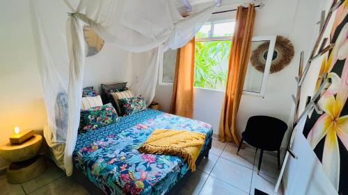 a bedroom with a bed and a window at Île tropical lodges in Sainte-Anne