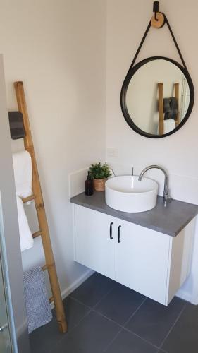 a bathroom with a sink and a mirror on the wall at At Home Apartments in Sale