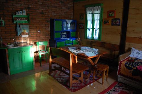 a kitchen and dining room with a table and a kitchen with a bed at Terzica avlija in Sevojno