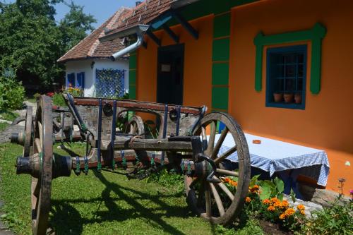 a house with a wooden cart in front of it at Terzica avlija in Sevojno