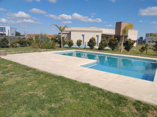 a swimming pool in the middle of a yard with grass at Casa Renata Canning Ezeiza in Canning