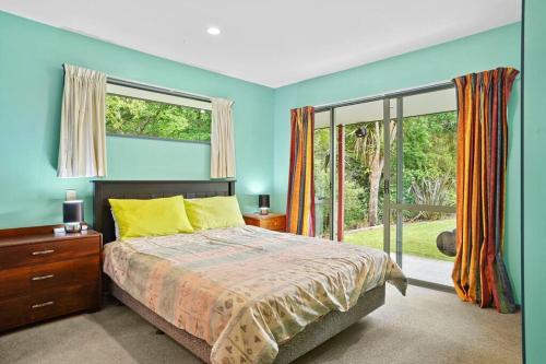 a bedroom with a bed and a large window at Family Hideaway in Hanmer Springs