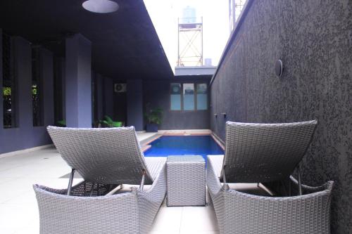 a patio with two chairs and a swimming pool at HAC Apartments in Lekki