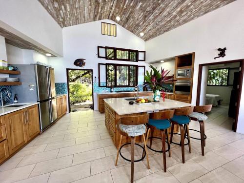 a kitchen with a large island with bar stools at Wild Serenity's Beach Villa in Castries