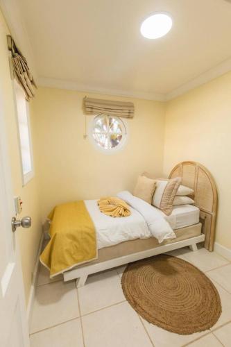 una camera con letto, finestra e tappeto di Villa Yemanjá a Lowlands