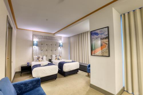 a hotel room with two beds and a couch at Marsden Viaduct in Auckland