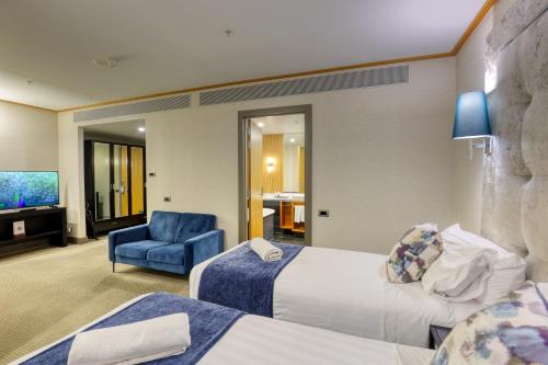 a hotel room with two beds and a blue chair at Marsden Viaduct in Auckland
