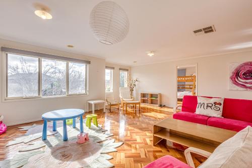 a living room with a red couch and a table at StayAU Family Home Comfort in Caroline Springs in Caroline Springs
