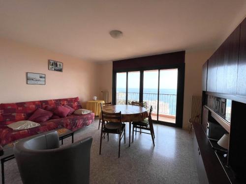 un salon avec un canapé rouge et une table dans l'établissement T3 avec loggia, parking couvert, proche plage - FR-1-309-62, à Banyuls-sur-Mer