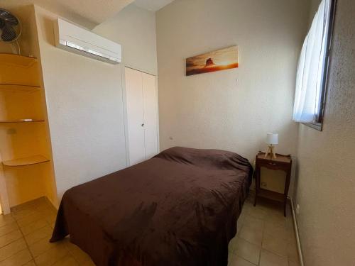 une petite chambre avec un lit et une fenêtre dans l'établissement Appartement rénové T2 à Banyuls, climatisé, terrasse, parking, proche crique et thalasso - FR-1-309-235, à Banyuls-sur-Mer