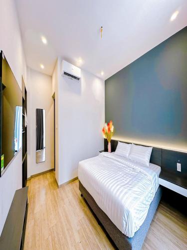 une chambre avec un grand lit avec un mur bleu dans l'établissement Chuỗi Villa Tuần Châu 8 Ngủ - Bể bơi riêng - sân vườn - BBQ, à Hạ Long