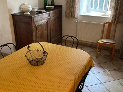 une table jaune avec un panier en haut dans l'établissement Gîte authentique avec wifi, cheminée à Véranne - FR-1-496-255, à Véranne