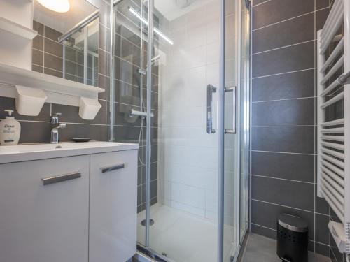 une salle de bain avec une douche en verre et un lavabo dans l'établissement Appartement 1 chambre, balcon et accès direct à la plage - FR-1-197-596, à Les Sables-dʼOlonne