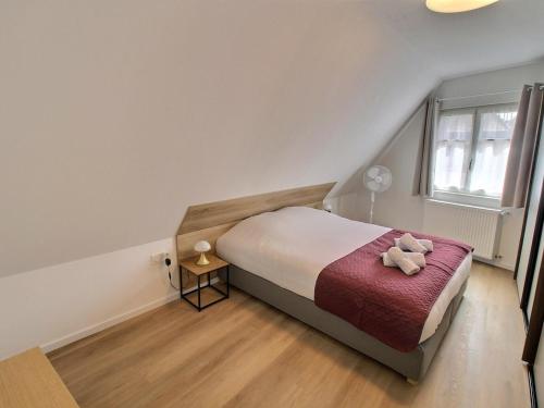 une chambre avec un lit avec un ours en peluche dessus dans l'établissement Gîte rénové de charme à Gueberschwihr, au cœur du vignoble, idéal pour 2 personnes - FR-1-722-10, à Gueberschwihr