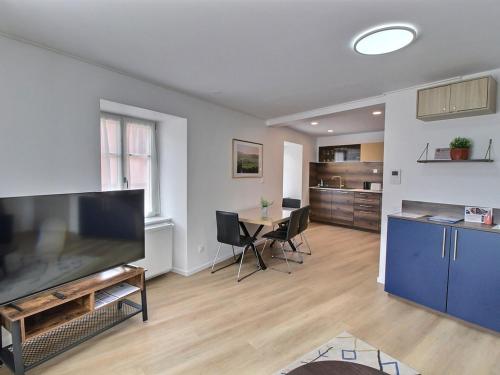 - un salon avec une grande télévision et une table dans l'établissement Gîte Alsacien pour 4 pers. rénové avec goût au cœur du vignoble, route des Vins, Gueberschwihr. - FR-1-722-9, à Gueberschwihr