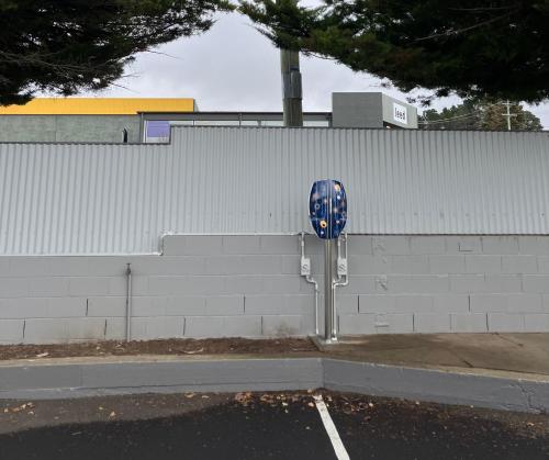 a blue parking meter in a parking lot next to a wall at Cooma Motor Lodge Motel in Cooma