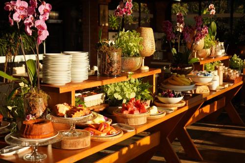a long table with plates and bowls of food at Pousada Vale do Dinossauro in São Pedro