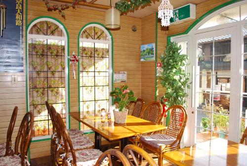 a dining room with a wooden table and chairs at Hotel Cotton 100% in Nara