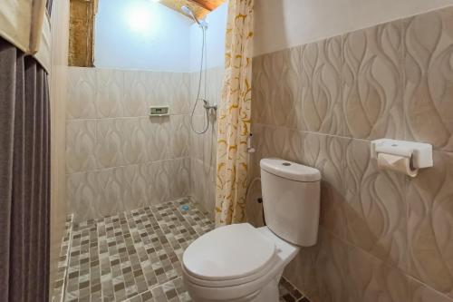 a small bathroom with a toilet and a shower at Samsara Desa in Kintamani