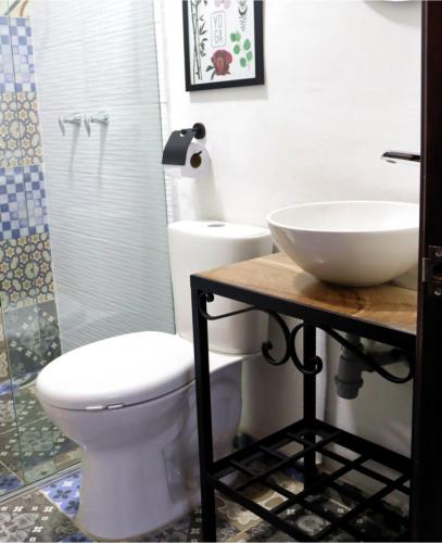 a bathroom with a toilet and a sink at Hotel Ambar La Morada in Buga