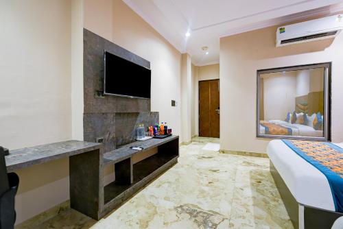 a hotel room with a bed and a flat screen tv at The Pearl Plaza Hotel - Walking Distance From New Delhi Railway Station and Connaught Place in New Delhi