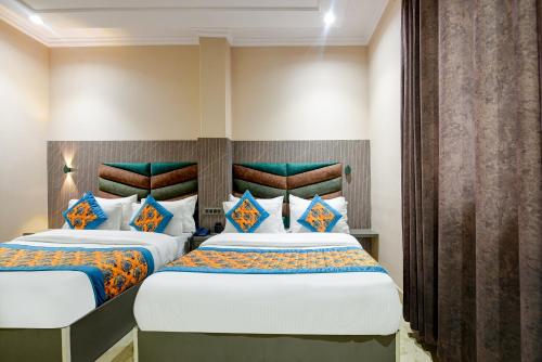 a hotel room with two beds in a room at The Pearl Plaza Hotel - Walking Distance From New Delhi Railway Station and Connaught Place in New Delhi