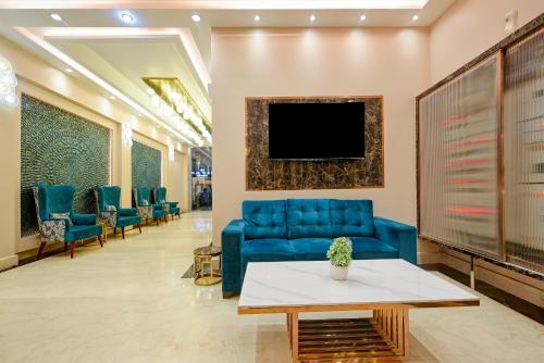 a waiting room with a blue couch and a tv at The Pearl Plaza Hotel - Walking Distance From New Delhi Railway Station and Connaught Place in New Delhi