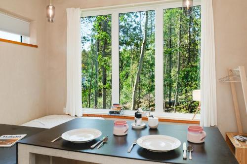 a kitchen with a table with two plates and a window at Black Spruce - Yellow Door in Whitehorse