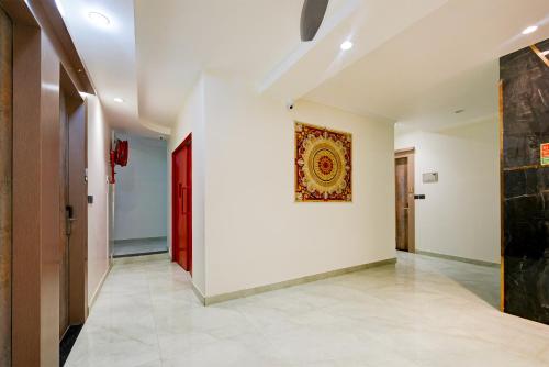 a hallway with a white wall and a painting on a wall at The Pearl Plaza Hotel - Walking Distance From New Delhi Railway Station and Connaught Place in New Delhi