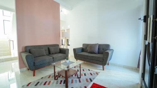 two chairs and a coffee table in a living room at Guest House Pesona Sidoarum Jogja in Godean