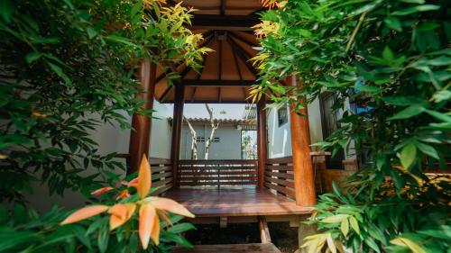 a wooden bench in a garden with trees at Guest House Pesona Sidoarum Jogja in Godean