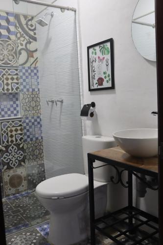 a bathroom with a toilet and a sink and a shower at Hotel Ambar La Morada in Buga