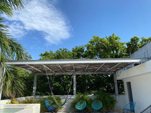 a pergola with chairs and a swing at Studios Downtown Cancun in Cancún
