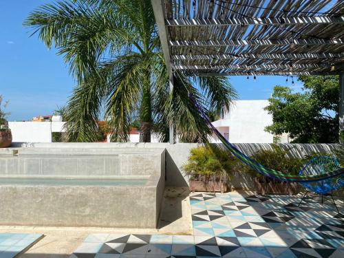 a hammock in a patio with palm trees and a pool at Studios Downtown Cancun in Cancún