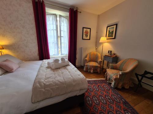 a bedroom with a bed and two chairs and a window at Chambre chaleureuse "Toscane" avec lit 160cm, salle d'eau privative et petit-déjeuner inclus. - FR-1-591-600 in Châteauroux