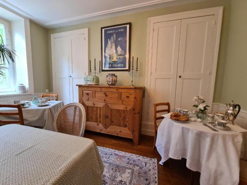 a room with two tables and a dresser in a room at Chambre spacieuse avec grand lit et salle d'eau privée, petit-déjeuner inclus - Châteauroux - FR-1-591-601 in Châteauroux