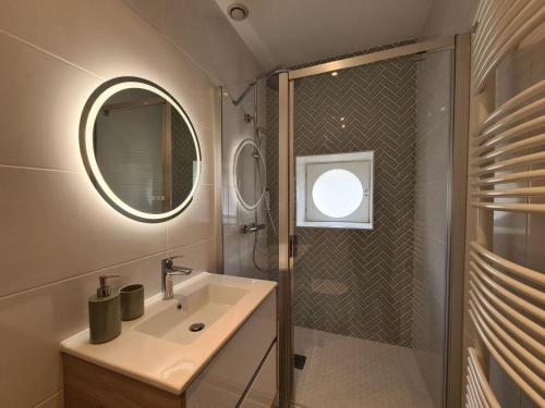 un bagno con lavandino e doccia con specchio di Chambre "Diane" avec salle d'eau privative et petit-déjeuner à Châteauroux - FR-1-591-602 a Châteauroux