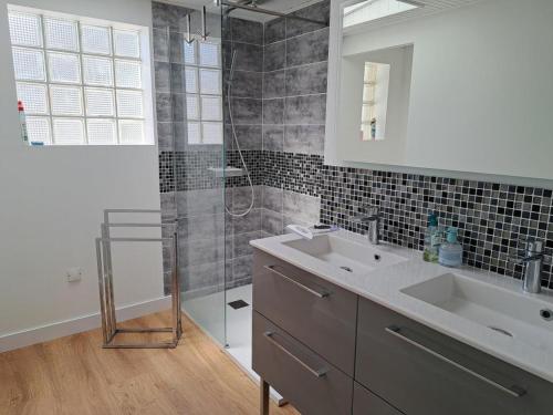 une salle de bain avec deux lavabos et une douche en verre dans l'établissement Maison de charme avec grand jardin, terrasse et WIFI, proche plage et commerces - FR-1-323-551, à Saint-Hilaire-de-Riez