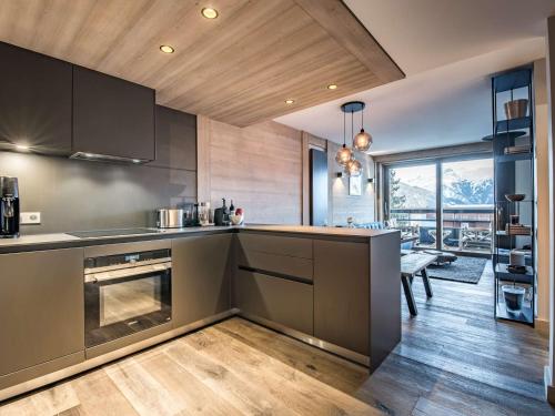 d'une cuisine équipée d'appareils en acier inoxydable et d'une grande fenêtre. dans l'établissement Appartement 51 m² - 4 pers - Courchevel Village - Centre station - Proche pistes - SPA - Parking - FR-1-631-201, à Courchevel
