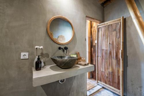 a bathroom with a bowl sink and a mirror at Luxury Bamboo Villa near Beach in Canggu