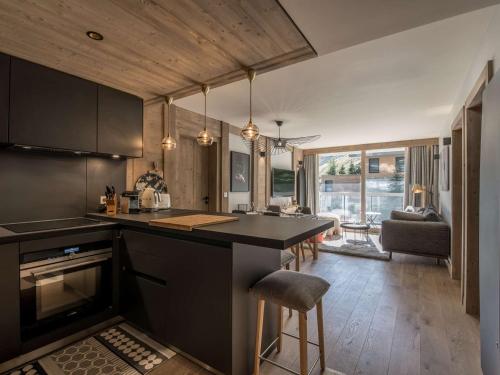 une cuisine avec un comptoir noir et une salle à manger dans l'établissement Appartement 6 pers - Courchevel Village - Centre station - Pistes à deux pas - SPA inclus - FR-1-631-200, à Courchevel